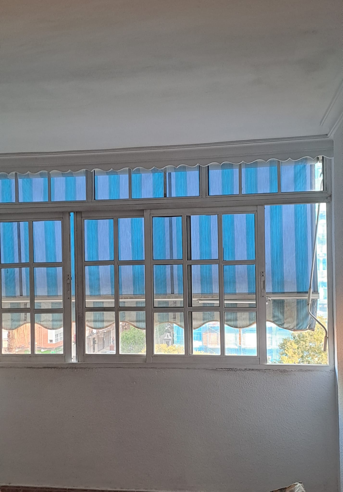 Cierre de aluminio blanco, con ventanas abatibles, persianas y cristal climalit